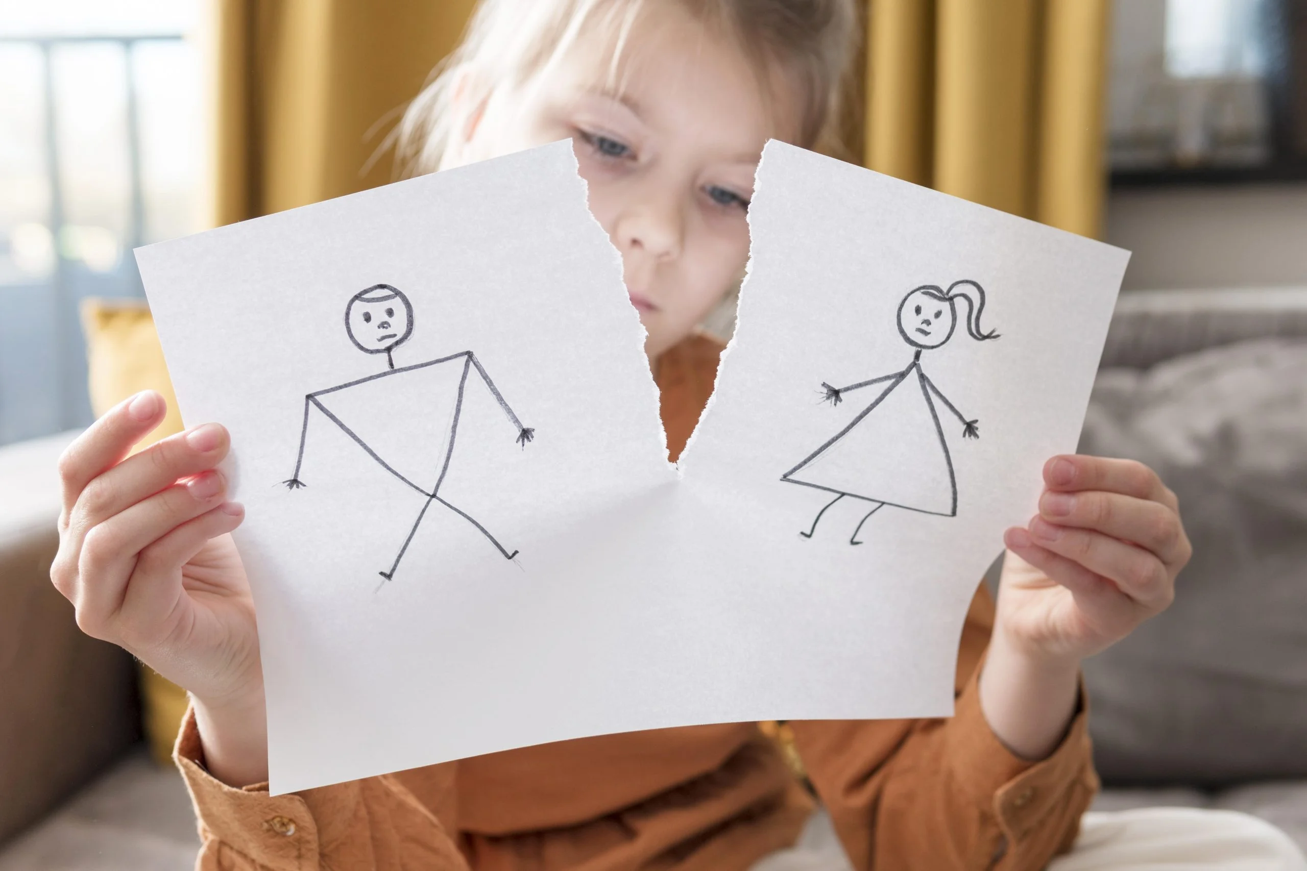 Photo d'une petite fille déchirant un dessin représentant ses parents